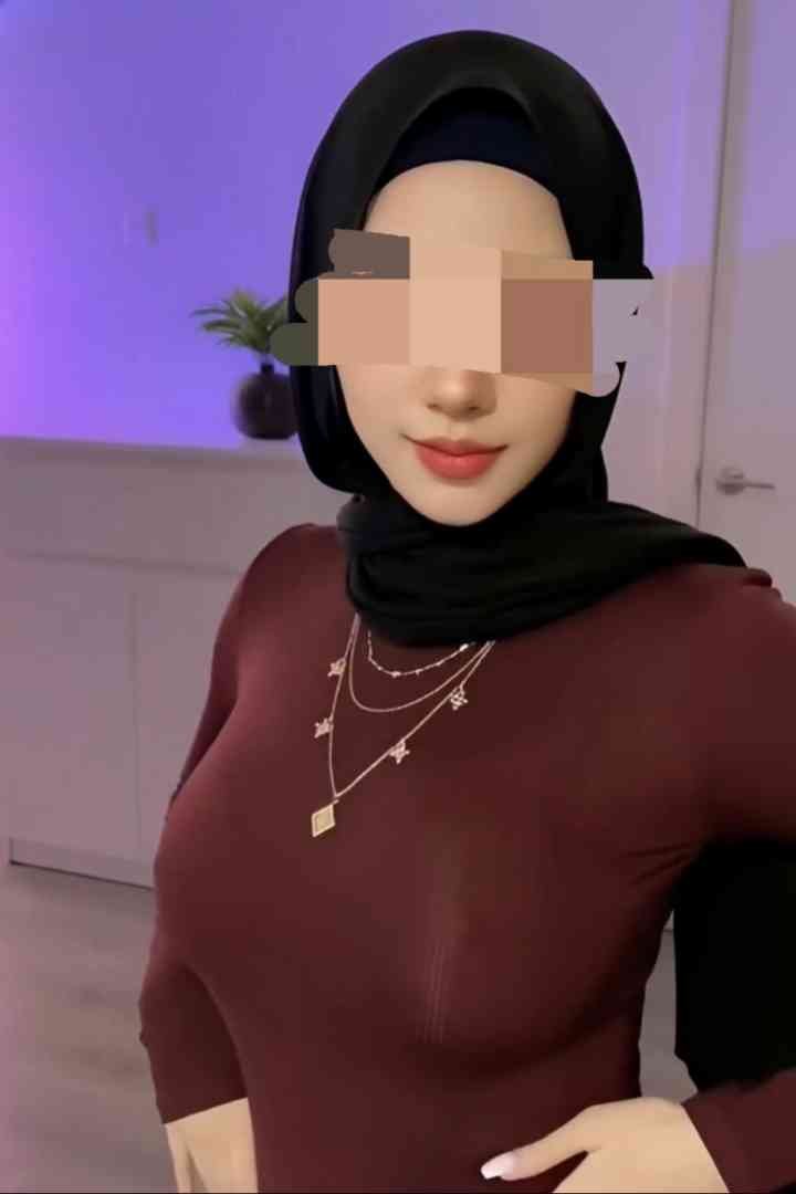 Woman in a hijab and maroon top wearing a layered necklace.