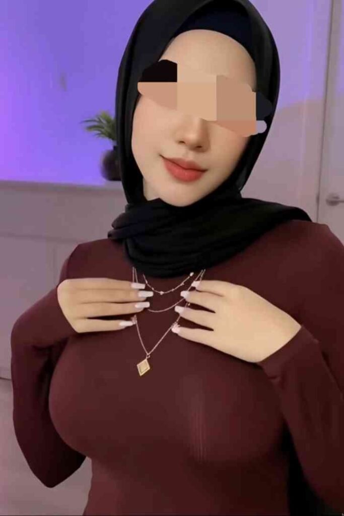 Woman in hijab and maroon dress wearing a necklace